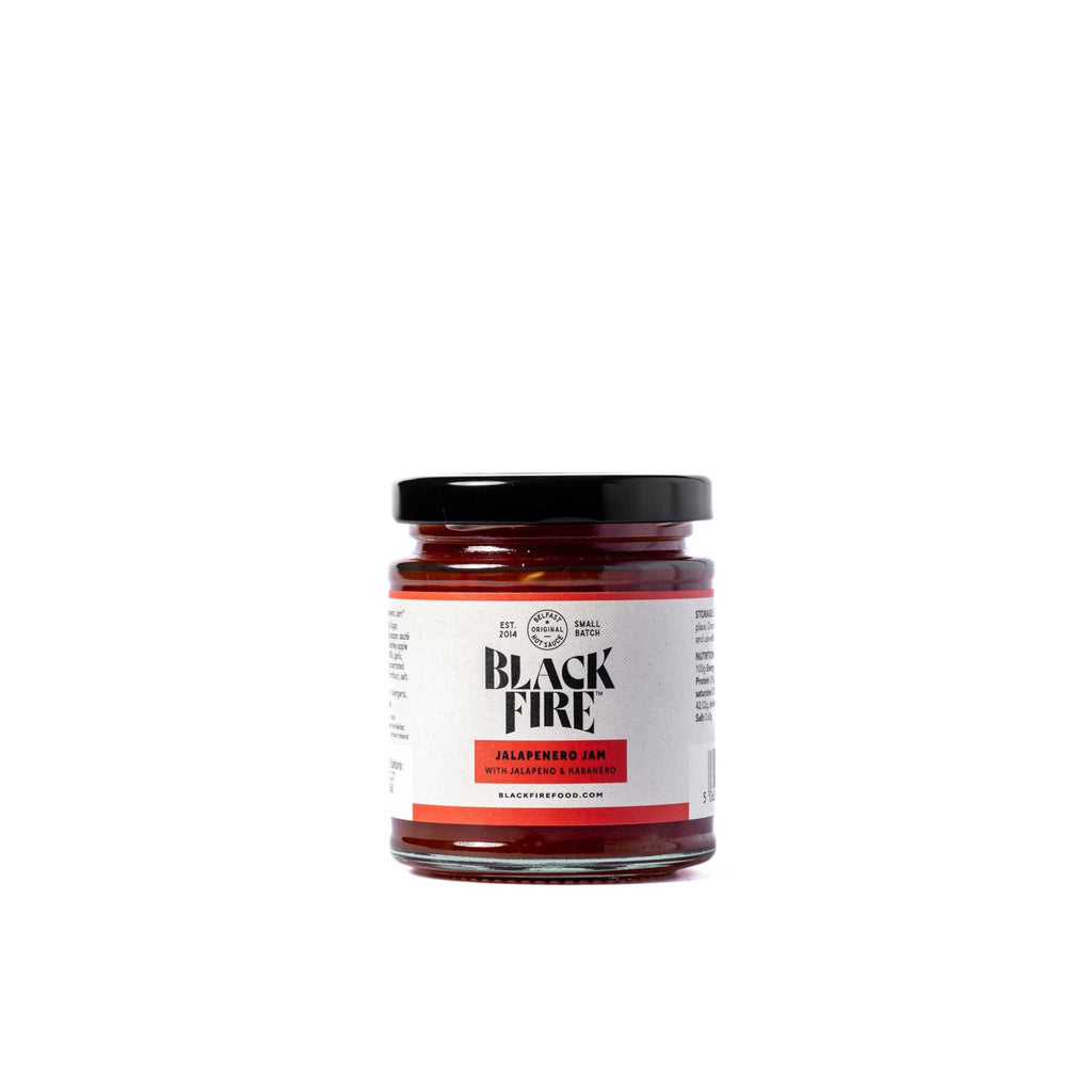 Blackfire Jalapeño Jam jar with spicy red chili spread and black lid isolated on white background