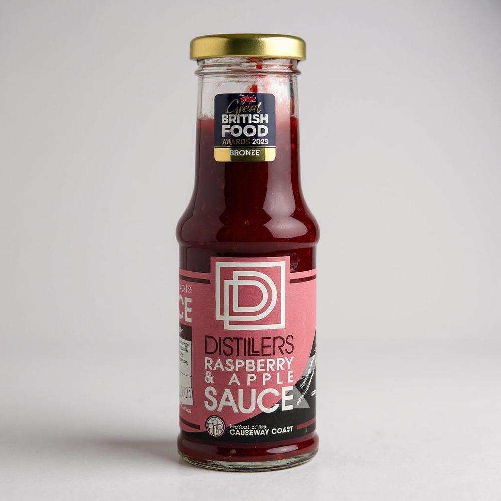Distillers Raspberry & Apple Sauce bottle with gold cap and award label, made from local ingredients and Bushmills Whiskey, ideal for desserts.