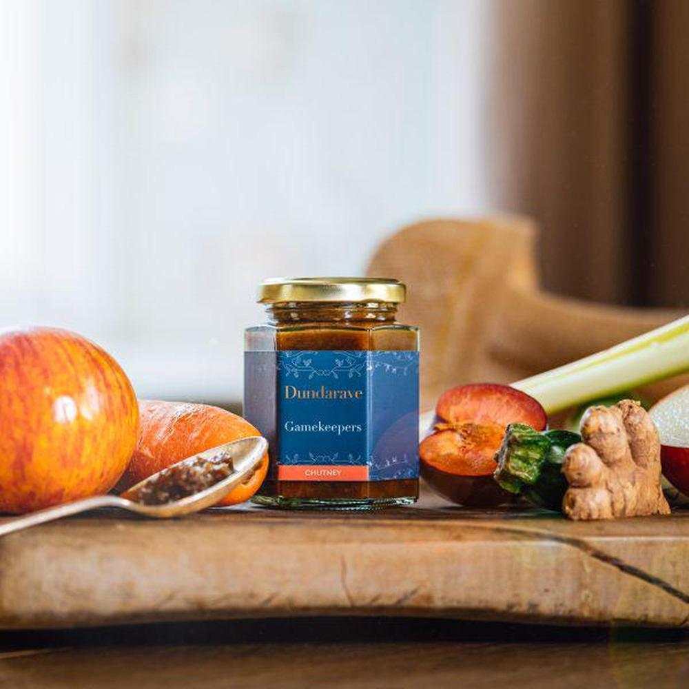 Dundarave Estate Gamekeepers Chutney jar with fresh fruits and vegetables on wooden surface