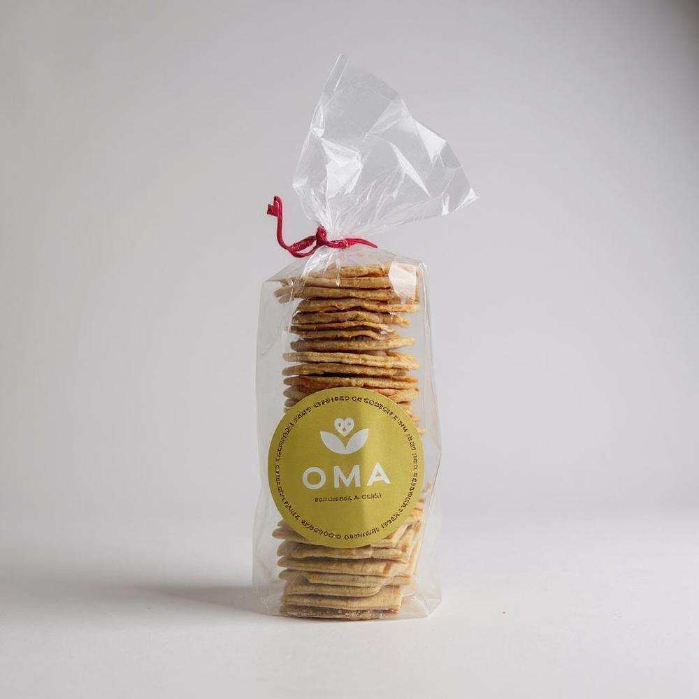 OMA crackers packaged in clear bag with yellow label, natural ingredient flavors including Parmesan and Chilli, Rosemary and Sea Salt, Beetroot and Fennel, Spinach and Dukkah, Flax Hemp and Chia Seed.